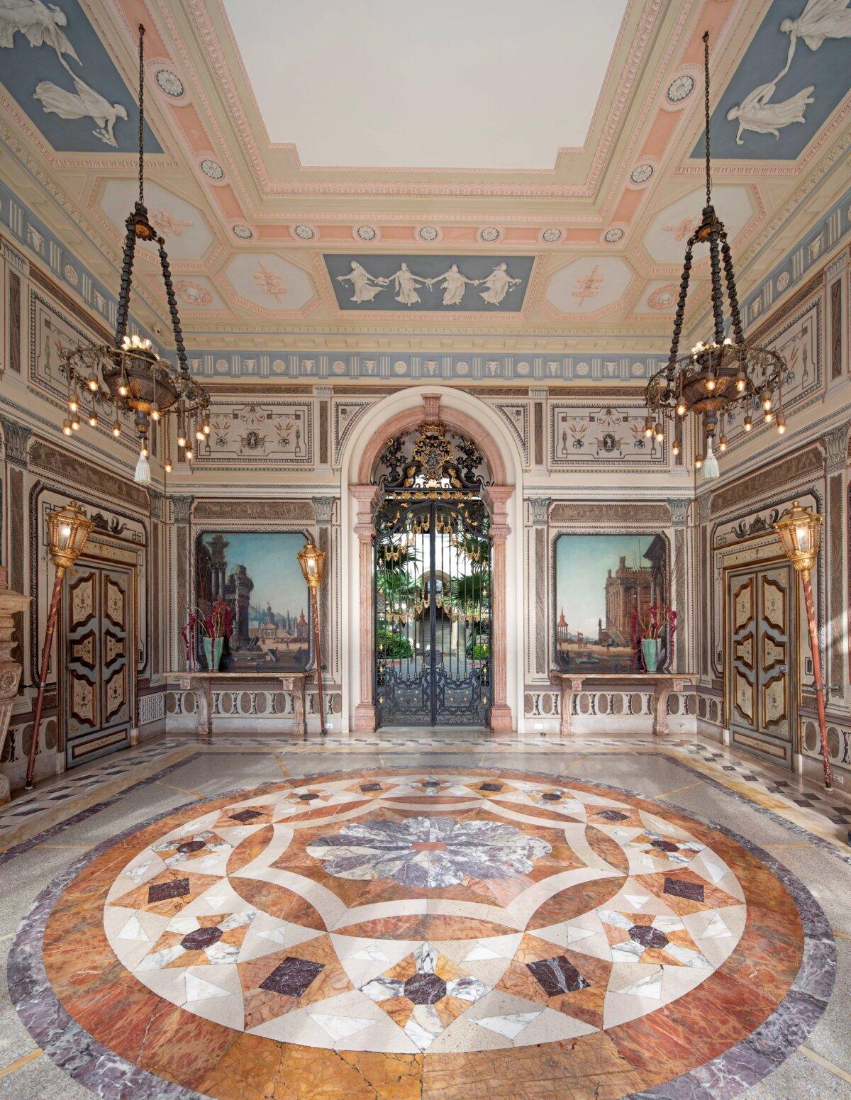 Craftsmanship and design adorn every square inch of space of the loggia (a covered exterior entrance), from the floor, to the walls made of ornamental wood and plaster, to the ceiling. The floor is inlaid with varicolored marble and terrazzo. The ceiling moldings are Wedgewood-inspired. Around the walls is a 15-panel canvas installation from the 18th century that depicts the conquest of Troy. The circa 17th-century gate was originally at the home of a diplomat in Venice, Italy. (Robin Hill/Vizcaya Museum and Gardens)