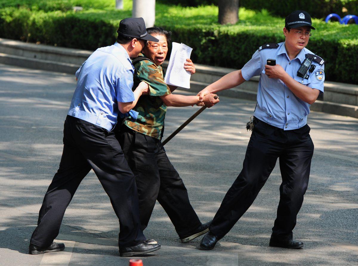 A petitioner is detained by police outside the Chaoyang Hospital, where people were protesting about medical and land grab issues, in Beijing on May 8, 2012. (Mark Ralston /AFP/Getty Images)