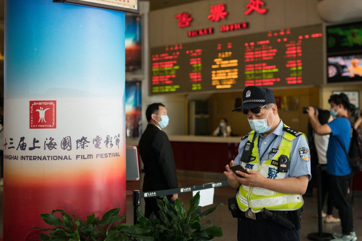 A police officer looks at his cellphone at Shanghai Film Center in Shanghai on July 25, 2020. (Yifan Ding/Getty Images)