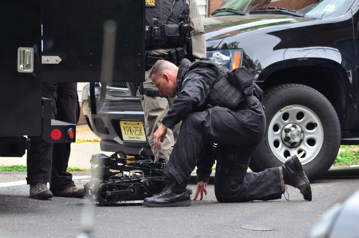 A state police swat team member readies a robot to enter a home where a man had barricaded himself in Trenton, N.J., on May 10, 2013. (The Trentonian, Scott Ketterer/AP Photo)