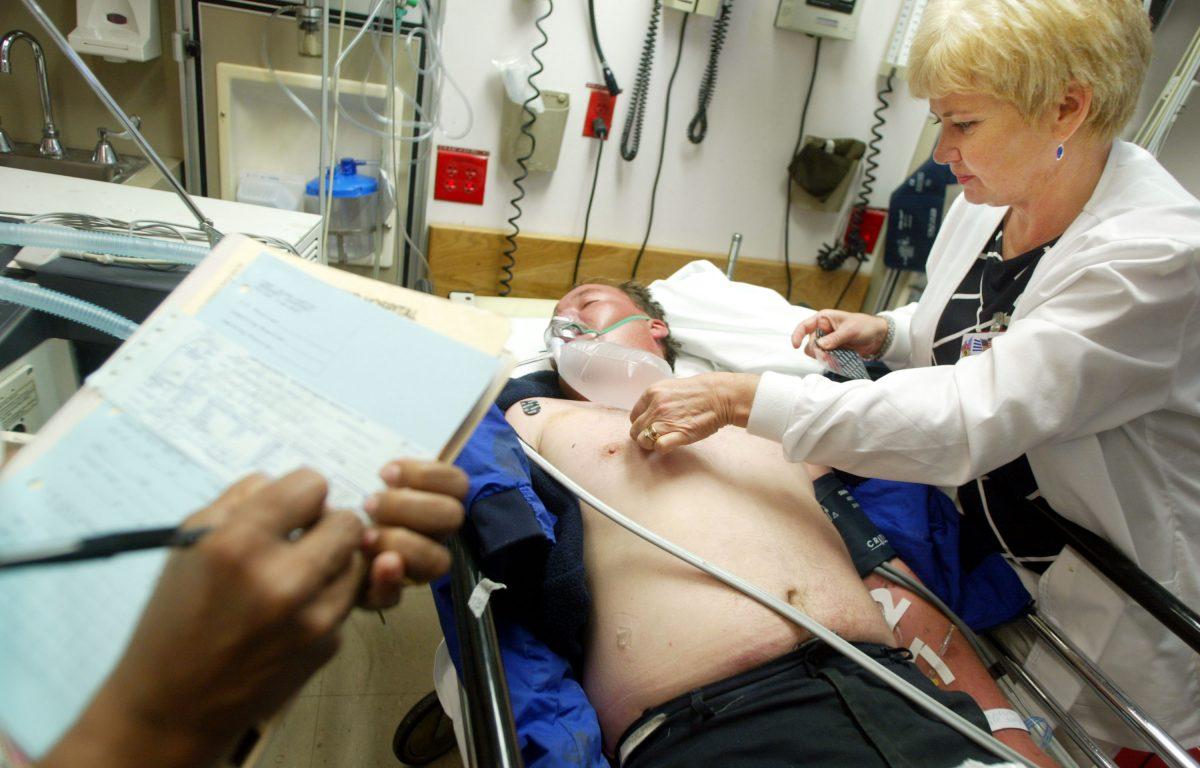 A medical-surgical technician performs triage on a patient as a nurse takes notes in the emergency room at Coney Island Hospital in New York on Sept. 5, 2002. (Mario Tama/Getty Images)