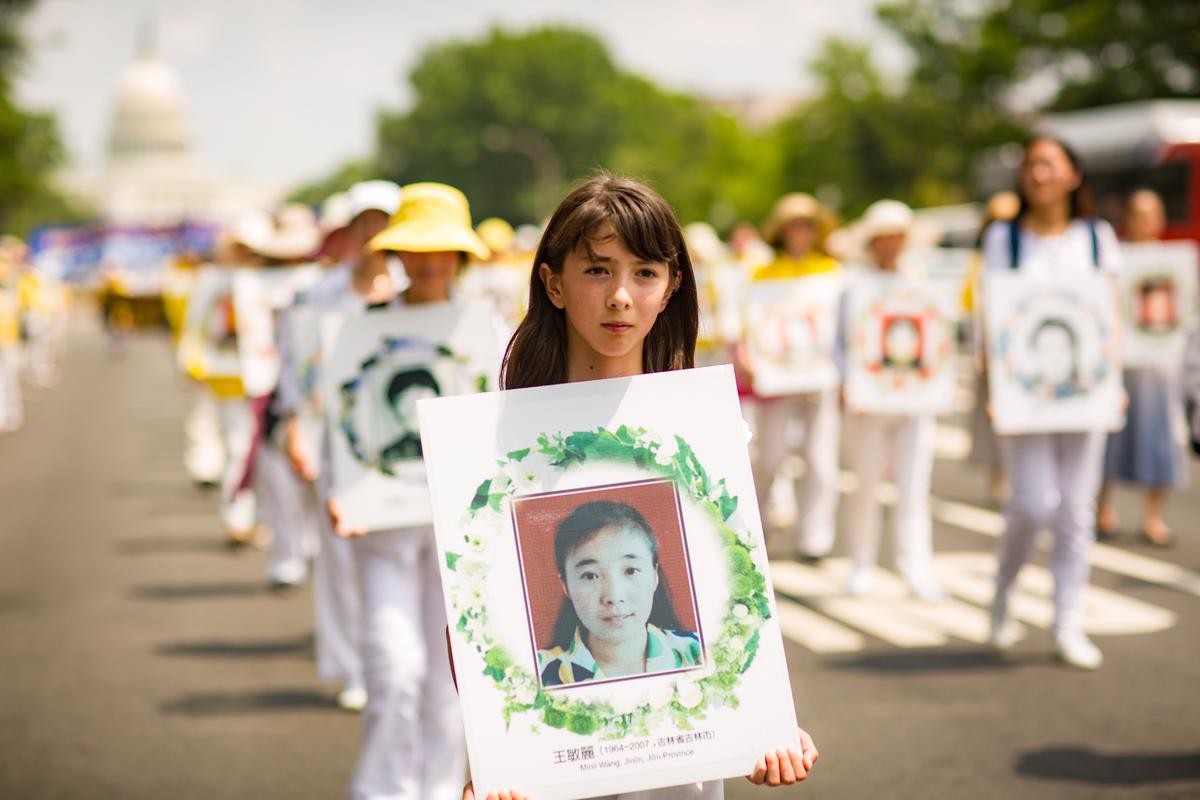 Falun Gong practitioners hold wreaths with photos of people who were killed in China for their beliefs. Hundreds of practitioners of the spiritual discipline marched in a parade in Washington on July 20, 2017, calling for an end to the persecution that started in China on July 20, 1999. (Benjamin Chasteen/The Epoch Times)
