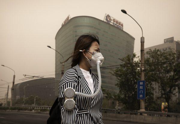 A Chinese woman wears a mask to protect against a sandstorm in Beijing, on May 4, 2017. (Kevin Frayer/Getty Images)