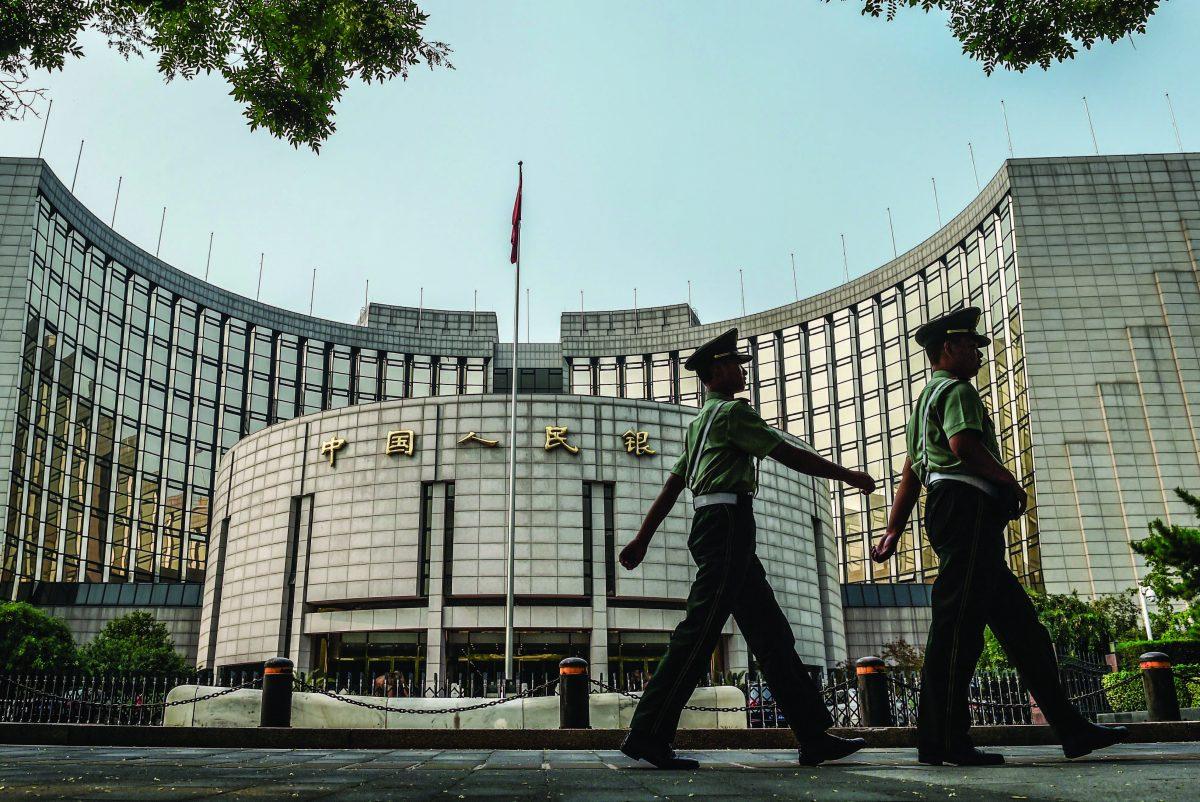 Paramilitary policemen patrol in front of the People's Bank of China, the central bank of China, in Beijing on July 8, 2015. (Greg Baker/AFP/Getty Images)