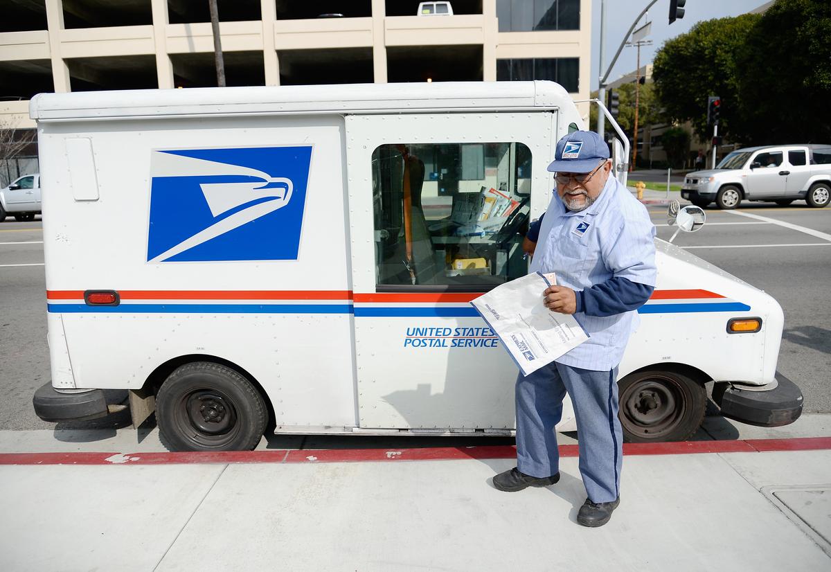 U.S. Postal Service employee Arturo Lugo delivers an Express Mail package during his morning route in Los Angeles, Calif., on Feb. 6, 2013. (Kevork Djansezian/Getty Images)