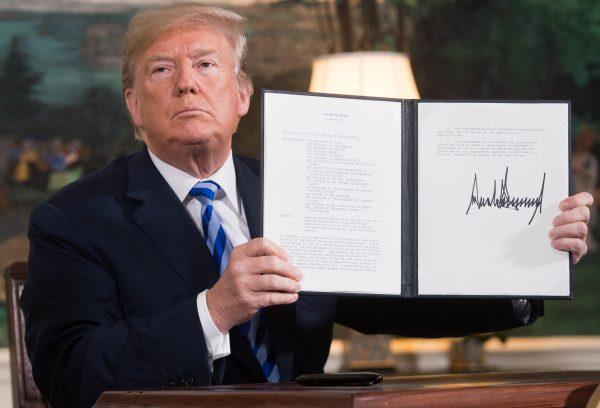 U.S. President Donald Trump signs a document reinstating sanctions against Iran after announcing the U.S. withdrawal from the Iran Nuclear deal at the White House in Washington, DC, on May 8, 2018. (Saul Loeb/AFP/Getty Images)