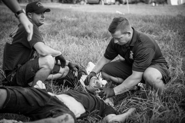 Local police and paramedics help a man who is overdosing in the Drexel neighborhood of Dayton, Ohio, on Aug. 3, 2017. (Benjamin Chasteen/The Epoch Times)