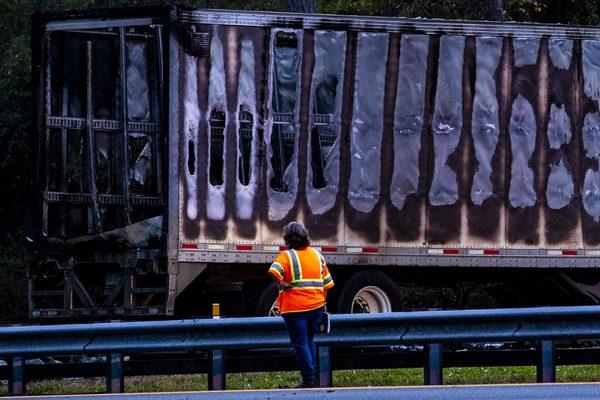 A worker looks at a charred semi-truck after a wreck with multiple fatalities on Interstate 75, south of Alachua, near Gainesville, Fa., Thursday, Jan. 3, 2019. (Lauren Bacho/The Gainesville Sun via AP)