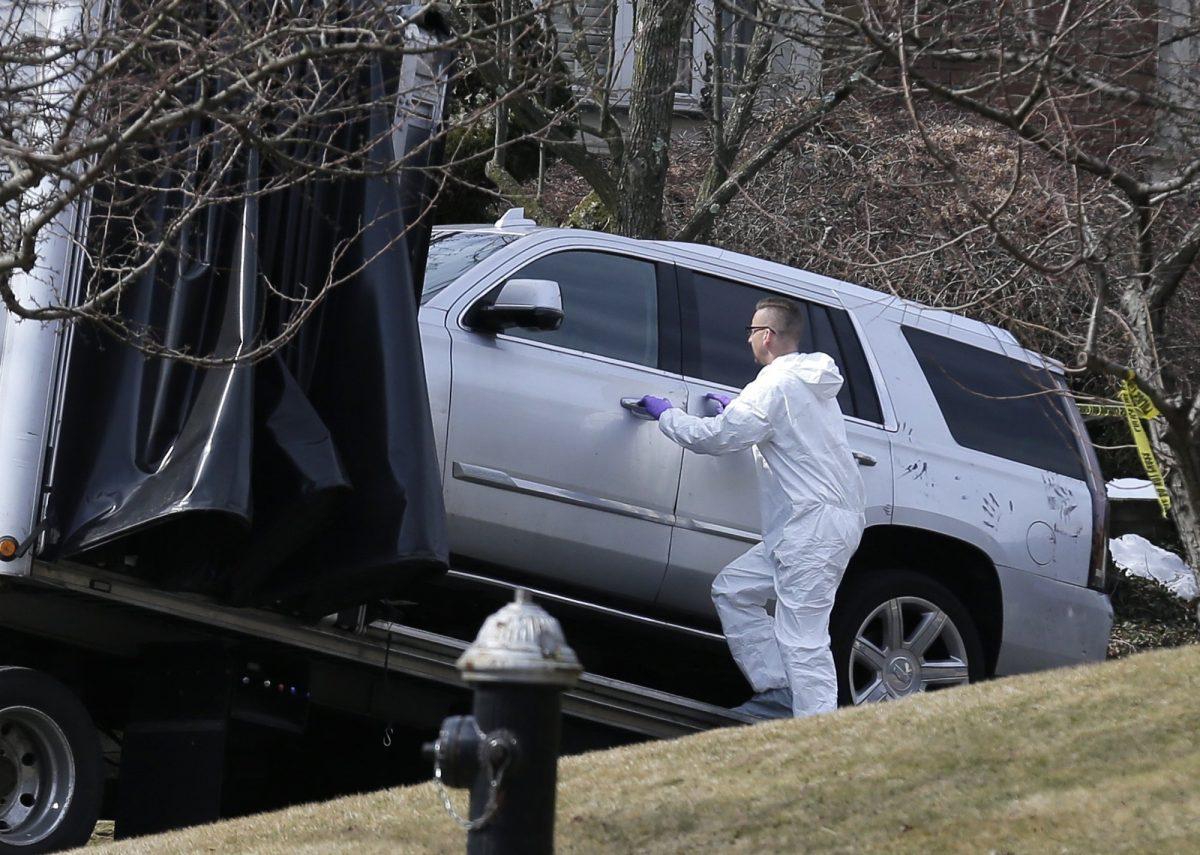 Crime scene investigators load a car that appears to have been checked for fingerprints onto a flatbed truck in the Staten Island borough of New York, on March 14, 2019. (Seth Wenig/AP Photo)