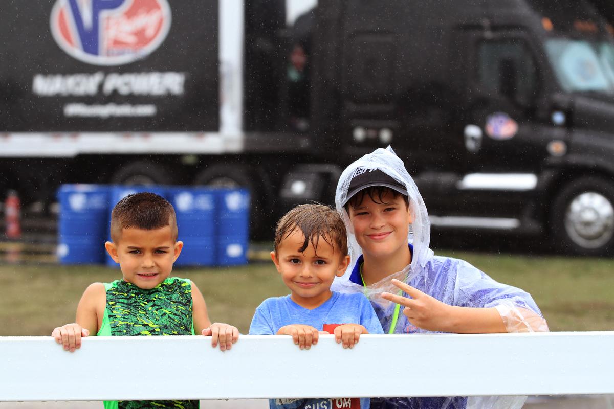 Wet but undismayed, young fans wait for the start of the race. (Chris Jasurek/Epoch Times)