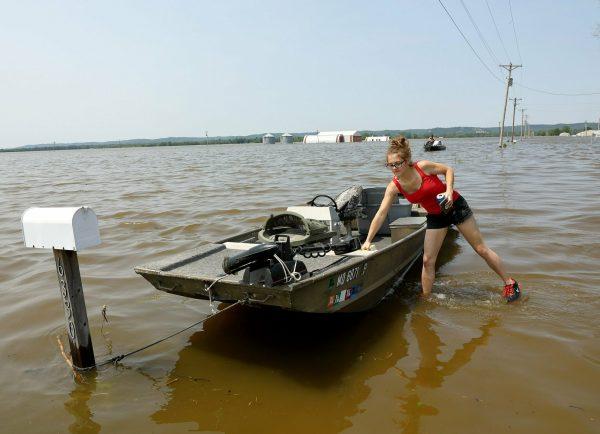 Emily Kientzel puts a cooler in her friend's boat as they prepare to take the boat out over floodwaters from the Mississippi River to his home outside of Portage des Sioux, Mo., on June 2, 2019. (David Carson/St. Louis Post-Dispatch via AP)
