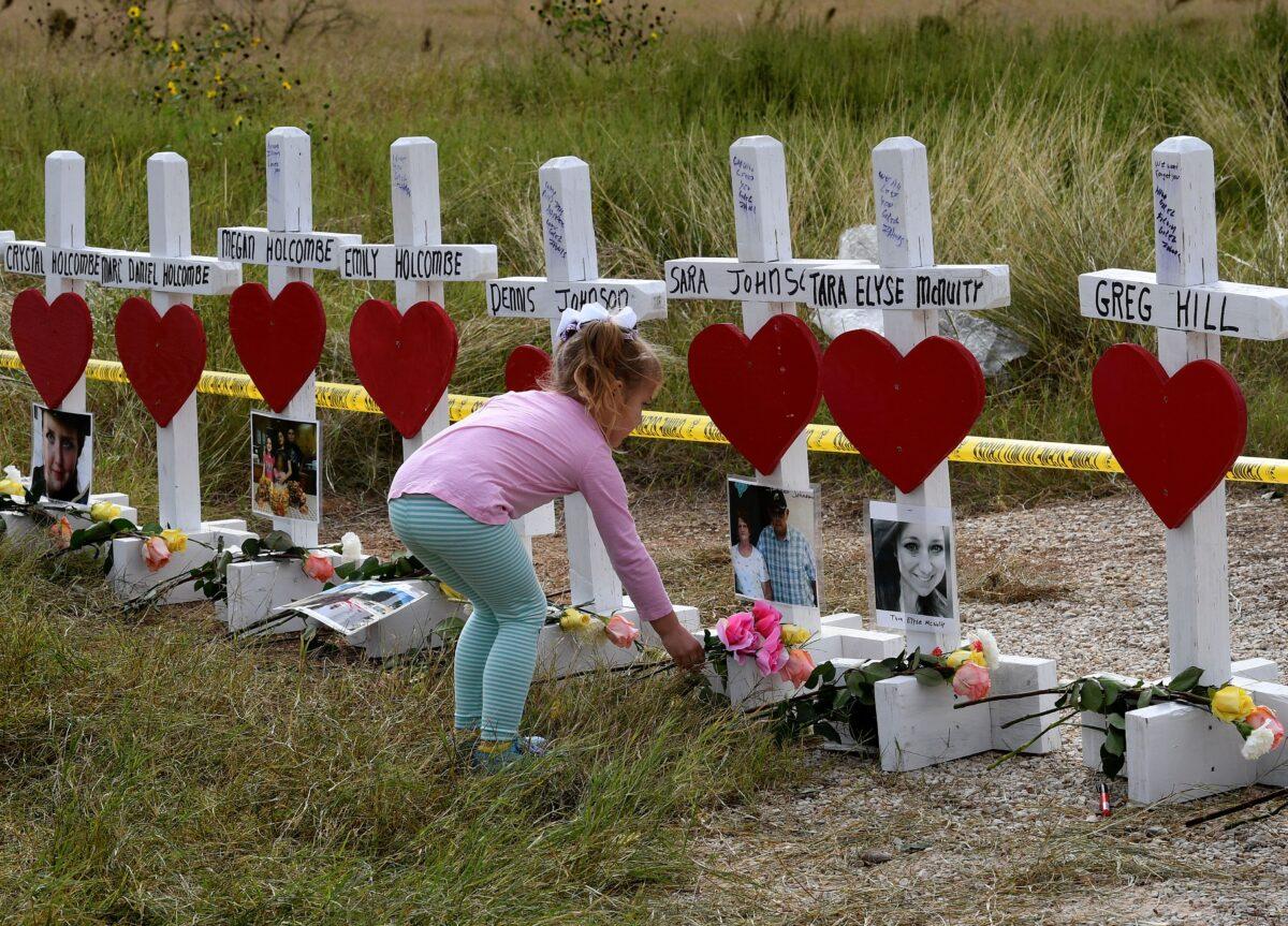 Shaelyn Gisler, 4, prepares to leave flowers on crosses named for the victims outside the First Baptist Church, the scene of a mass shooting that killed 26 people, in Sutherland Springs, Texas, on Nov. 9, 2017. (Mark Ralston/AFP via Getty Images)