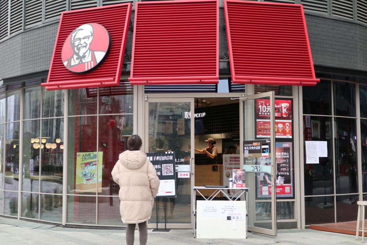 A customer waits to pick up her order outside a KFC restaurant in Chengdu, Sichuan Province, China, on Feb. 14, 2020. (cnsphoto via Reuters)