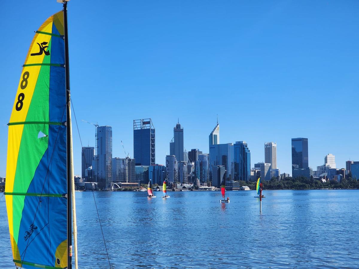 Perth CBD can be seen across the Swan River while people sail catamarans in South Perth, Western Australia, on March 16, 2024. (Susan Mortimer/The Epoch Times)