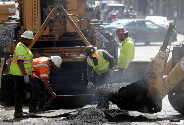 Construction workers smooth tar as they pave a road in San Francisco on Oct. 5, 2018. (Justin Sullivan/Getty Images)