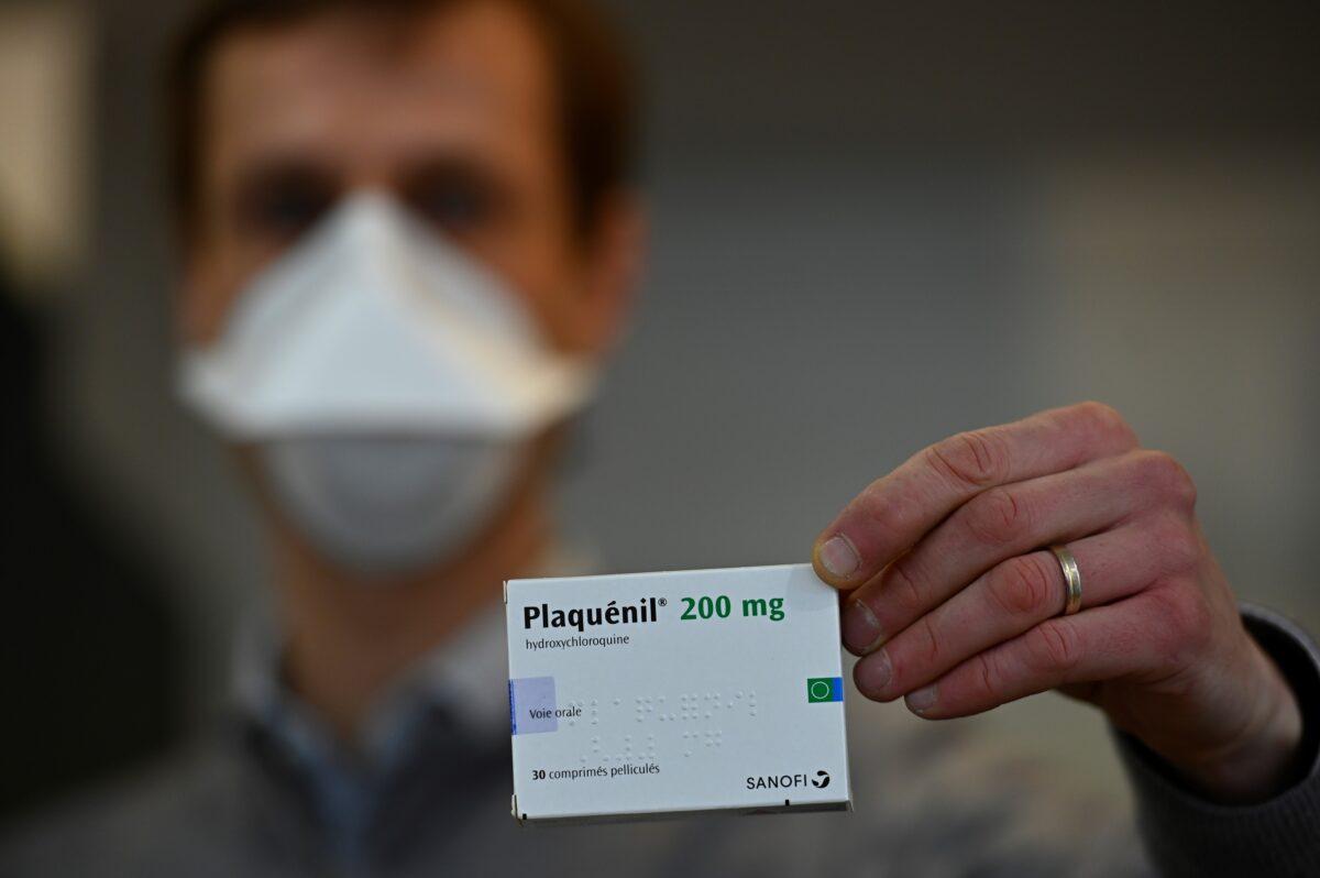 A pharmacist shows a box of antimalarial tablets in Rennes, France, on March 23, 2020. (Damien Meyer/AFP via Getty Images)
