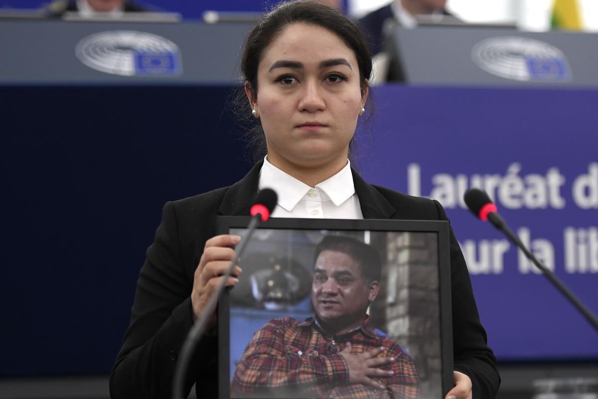 Jewher Ilham, daughter of Ilham Tohti, holds a portrait of her father during the award ceremony for his 2019 European Parliament's Sakharov human rights prize at the European Parliament in Strasbourg, eastern France, on Dec. 18, 2019. (Frederick Florin/AFP via Getty Images)
