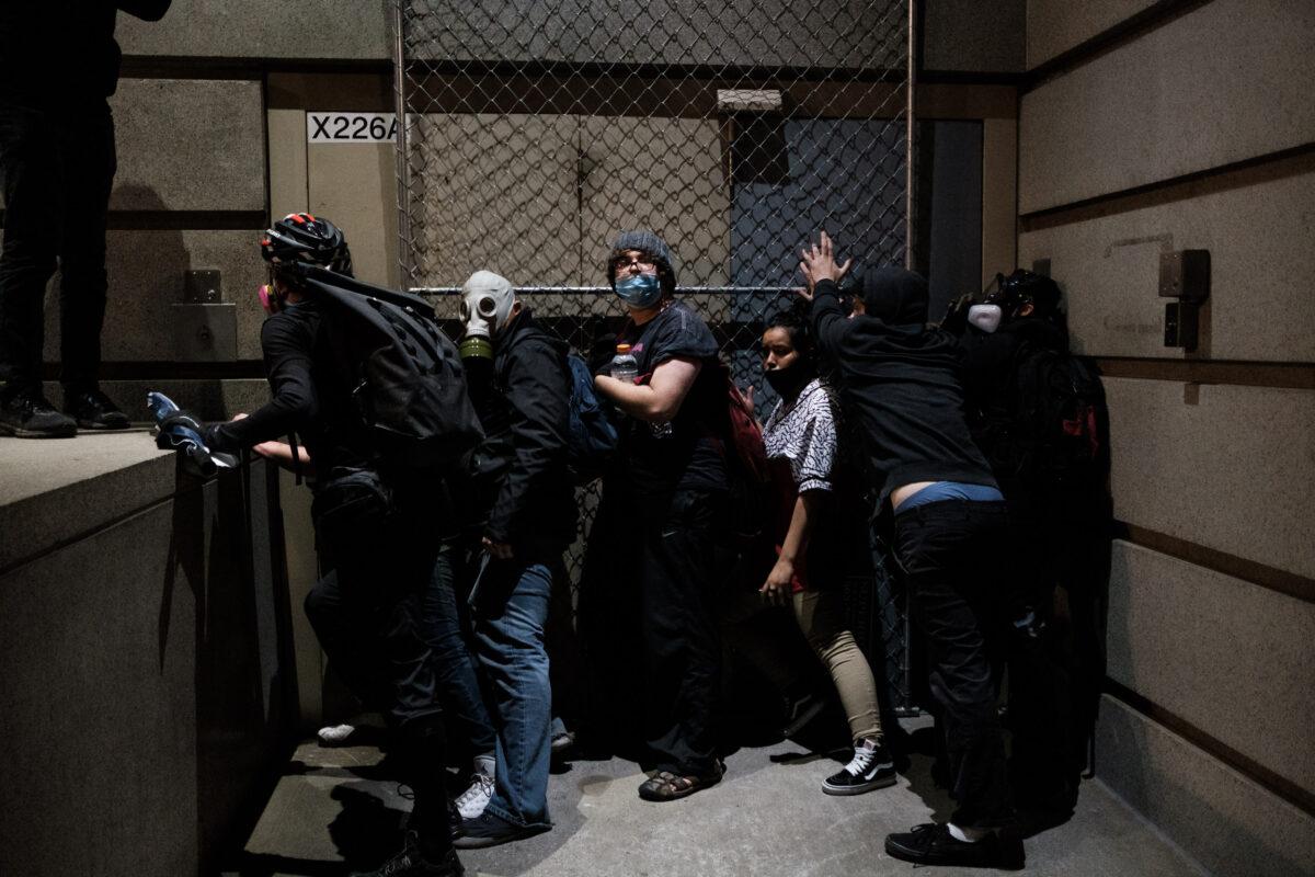 Demonstrators try blocking a door to the Multnomah County Justice Center in Portland, Ore., on July 17, 2020. (Mason Trinca/Getty Images)