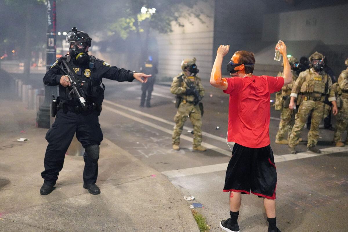 A federal officer tells fellow officers to arrest a man during riots outside the Mark O. Hatfield U.S. Courthouse in Portland, Ore., on July 21, 2020. (Nathan Howard/Getty Images)