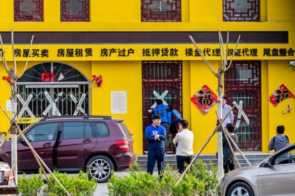 People are standing in front of a closed real estate agency in Anxin county in China's Hebei province on April 3, 2017. (STR/AFP via Getty Images)