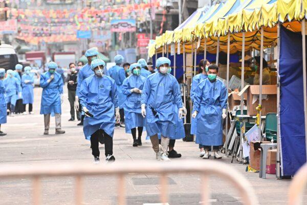 Medical workers walked on Temple Street in the lockdown area in Jordan, Kowloon, Hong Kong, on Jan. 24, 2021. (Adrian Yu/Epoch Times)