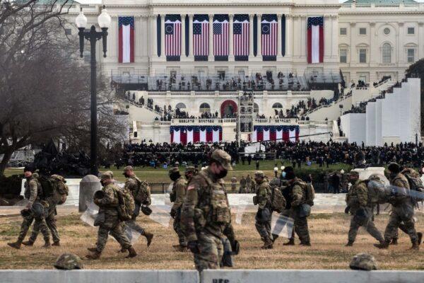 National Guard troops carry riot shields as they assume positions in the vicinity of the US Capitol during the inauguration of Joe Biden in Washington, on Jan. 20, 2021. (Roberto Schmidt/AFP via Getty Images)