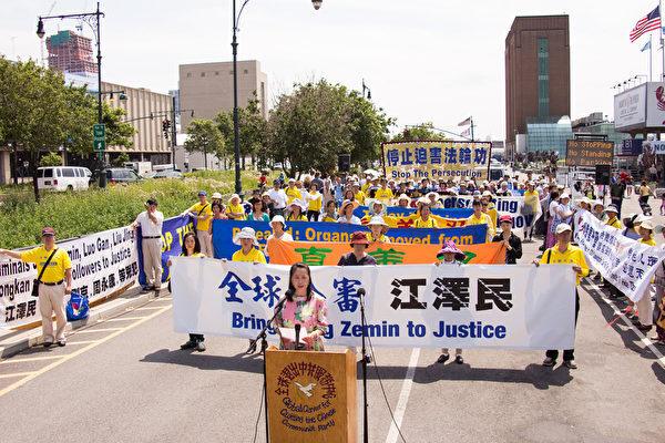 Falun Gong practitioners gathered across the street from the Chinese Consulate General in New York, displaying banners that read "Bring Jiang Zemin to Justice" and "The Crime of Genocide." (Dai Bing/The Epoch Times)