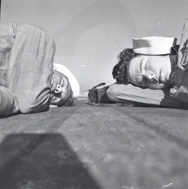 Sailors Arthur Moss (left) and Kenneth LeBouef (right) take a nap on the deck of the USS Bon Homme Richard, circa 1952. (Courtesy Arthur Moss)
