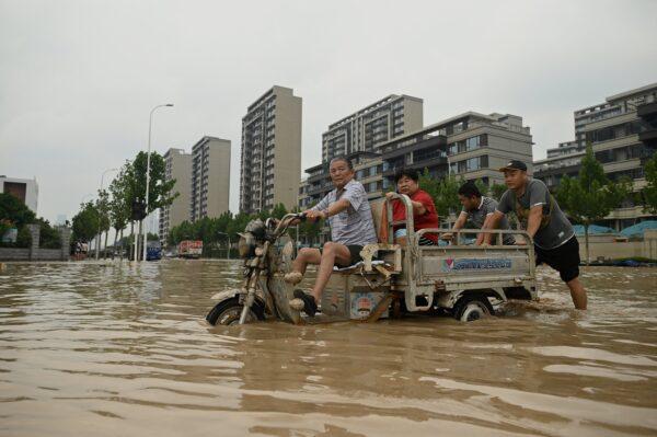 People wade through a flooded street in Zhengzhou, in China's Henan Province, on July 22, 2021. (Noel Celis/AFP via Getty Images)