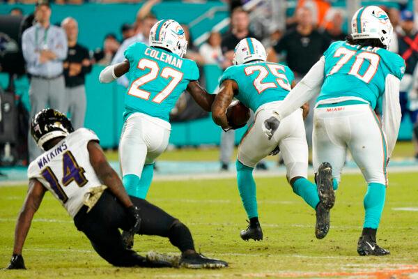 Miami Dolphins cornerback Xavien Howard (25) runs with the ball for a touchdown after recovering a fumble by Baltimore Ravens wide receiver Sammy Watkins (14) during the second half of an NFL football game, in Miami Gardens, Fla., on Nov. 11, 2021. (Wilfredo Lee/AP Photo)
