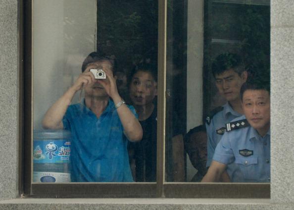 Court staff and police photograph the media at the Intermediate People's Court where Chinese politician Bo Xilai was indicted and his case is expected to be heard in Jinan, Shandong Province, on July 25, 2013. (Mark Ralston/AFP via Getty Images)