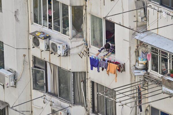 A woman hangs clothes outside her apartment during the second stage of the COVID-19 lockdown in the Jing'an district of Shanghai on April 6, 2022. (Hector Retamal/AFP via Getty Images)