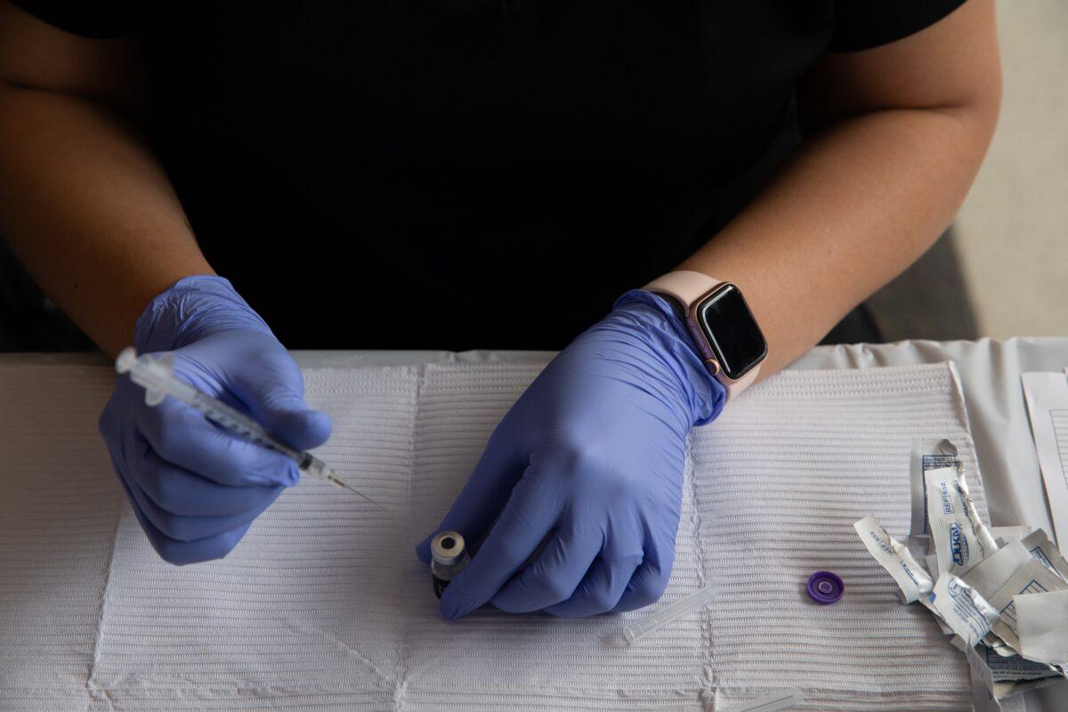 A healthcare worker prepares a COVID-19 vaccine in Southfield, Mich., in an Aug. 24, 2021, file image. (Emily Elconin/Getty Images)