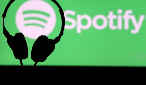 A headset is seen in front of a screen projection of Spotify logo, on April 1, 2018. (Dado Ruvic/Reuters)