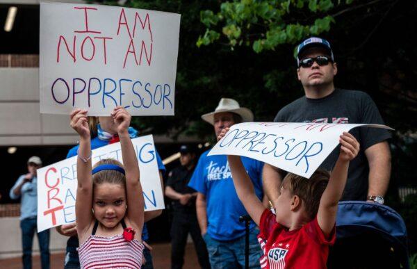 People hold up signs during a rally against critical race theory (CRT) being taught in schools at the Loudoun County Government center in Leesburg, Va, on June 12, 2021. (Andrew Caballero-Reynolds/AFP via Getty Images)