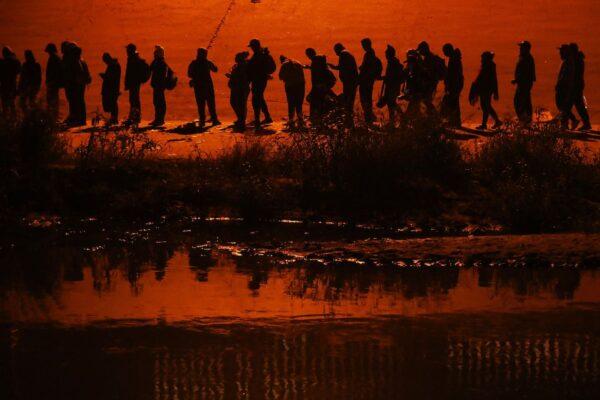 Illegal immigrants traveling in a caravan of more than 1,000 people cross the Rio Grande river into the United States, in Ciudad Juarez, Chihuahua state, Mexico, on Dec. 11, 2022. (Herika Martinez/AFP via Getty Images)