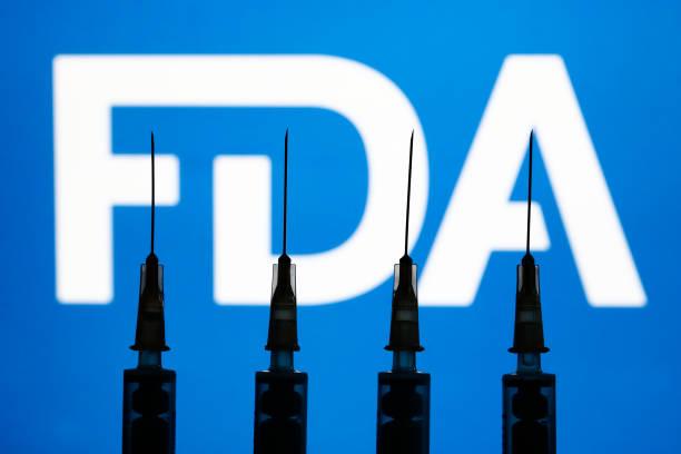 Medical syringes and the FDA logo displayed in the background are seen in this illustration photo taken in Krakow, Poland, on Dec. 2, 2021. (Jakub Porzycki/NurPhoto via Getty Images)