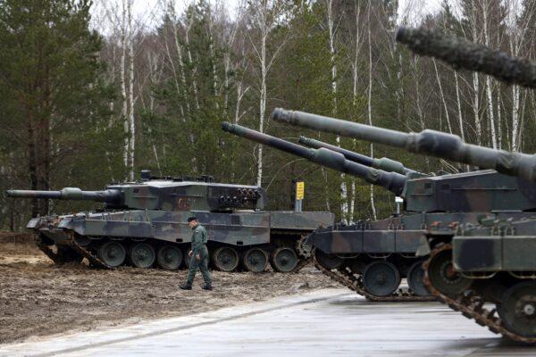 A Polish soldier walks next to Leopard 2 tanks during training at a military base and test range in Swietoszow, Poland, on Feb. 13, 2023. (Michal Dyjuk/AP Photo)