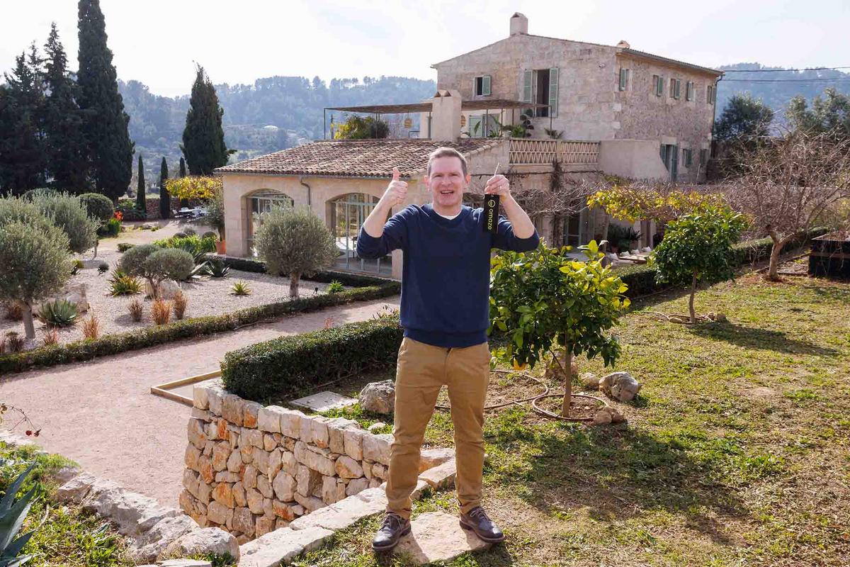 Mr. Dunlop shows off the keys to his new Spanish villa while standing on the property. (SWNS)