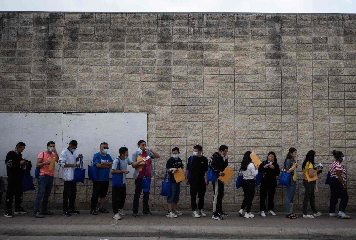 Illegal immigrants line up outside a processing center in Brownsville, Texas on May 11, 2023. (Andrew Caballero-Reynolds/AFP via Getty Images)