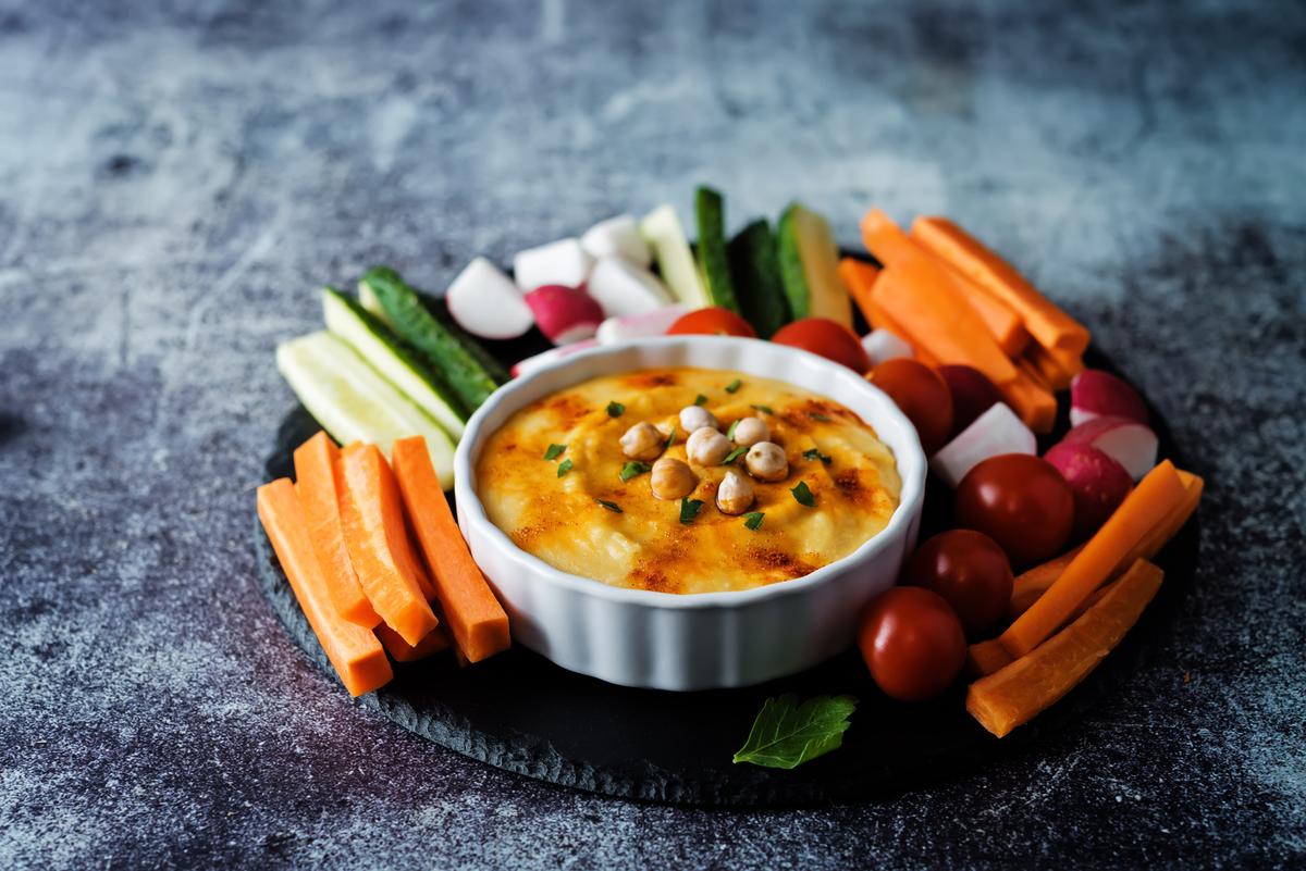 A hummus dip with an assortment of vegetables. A veggie dip is a great healthy snack. (nata_vkusidey/iStock/Getty Images Plus)