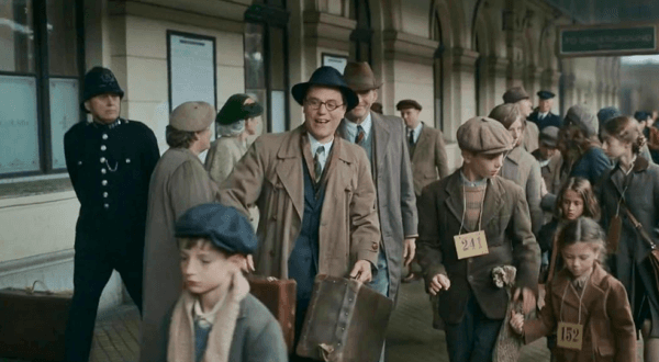Nicholas Winton (Johnny Flynn, center) taking refugee children from the train station to meet their new foster parents, in "One Life." (Warner Bros.)