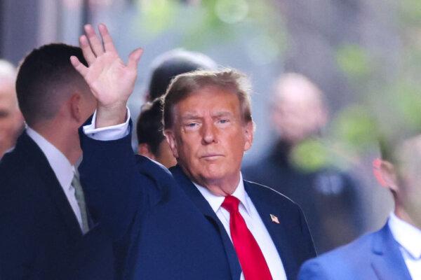 Former President Donald Trump waves as he departs Trump Tower for Manhattan Criminal Court, to attend the first day of his trial for allegedly covering up hush money payments linked to extramarital affairs, in New York City on April 15, 2024. (CHARLY TRIBALLEAU/AFP via Getty Images)