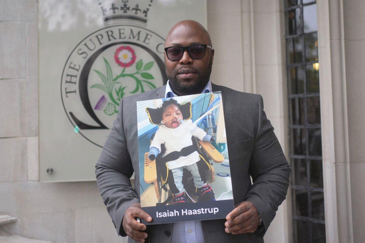 Lanre Haastrup holds a picture of his son, Isaiah Haastrup, outside the Supreme Court in London on April 15, 2024. (Yui Mok/PA)