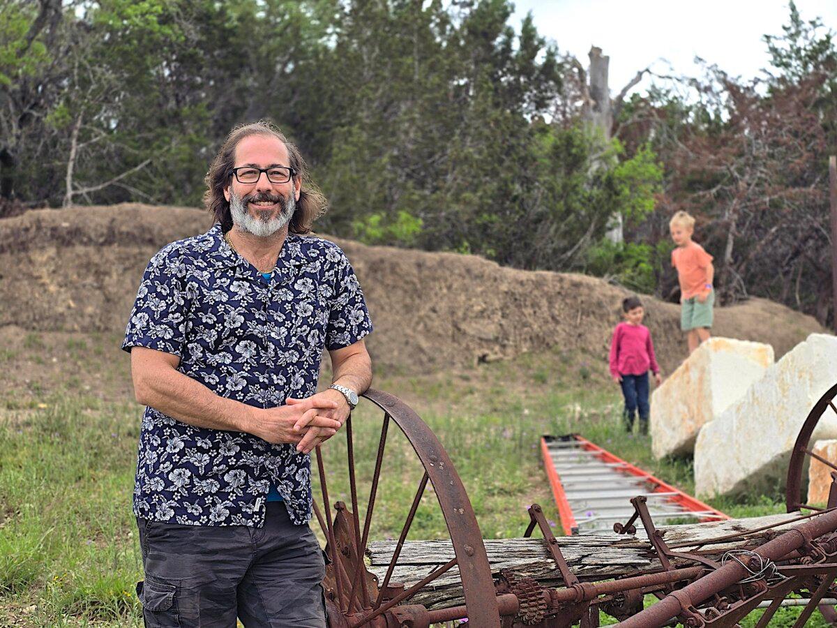 Guest speaker Dr. Andrew Kaufman stands near a farm implement during Confluence 2024 on April 5, 2024. (Allan Stein/The Epoch Times)