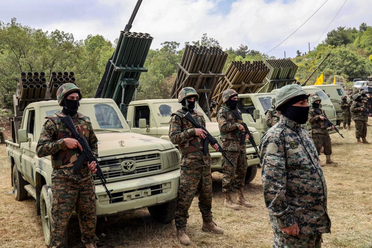 Lebanese Hezbollah fighters stand near multiple rocket launchers during a press tour in the southern Lebanese village of Aaramta, on May 21, 2023. (ANWAR AMRO/AFP via Getty Images)