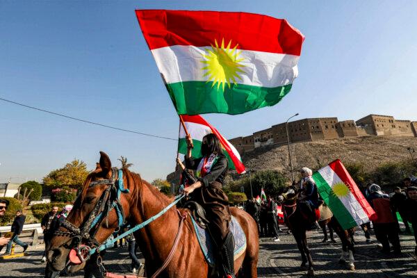 Masked women on horseback carry the Kurdish flag near the Arbil Citadel during a celebration of the Kurdish Flag Day in Arbil, the capital of Iraq's northern autonomous Kurdish region, on Dec. 17, 2024. (Safin Hamid/AFP via Getty Images)