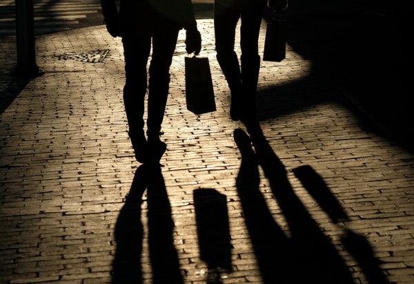 Shoppers cast shadows as they carry their bags along the waterfront in Portland, Maine, on Dec. 26, 2024. (Kevin Lamarque/Reuters)