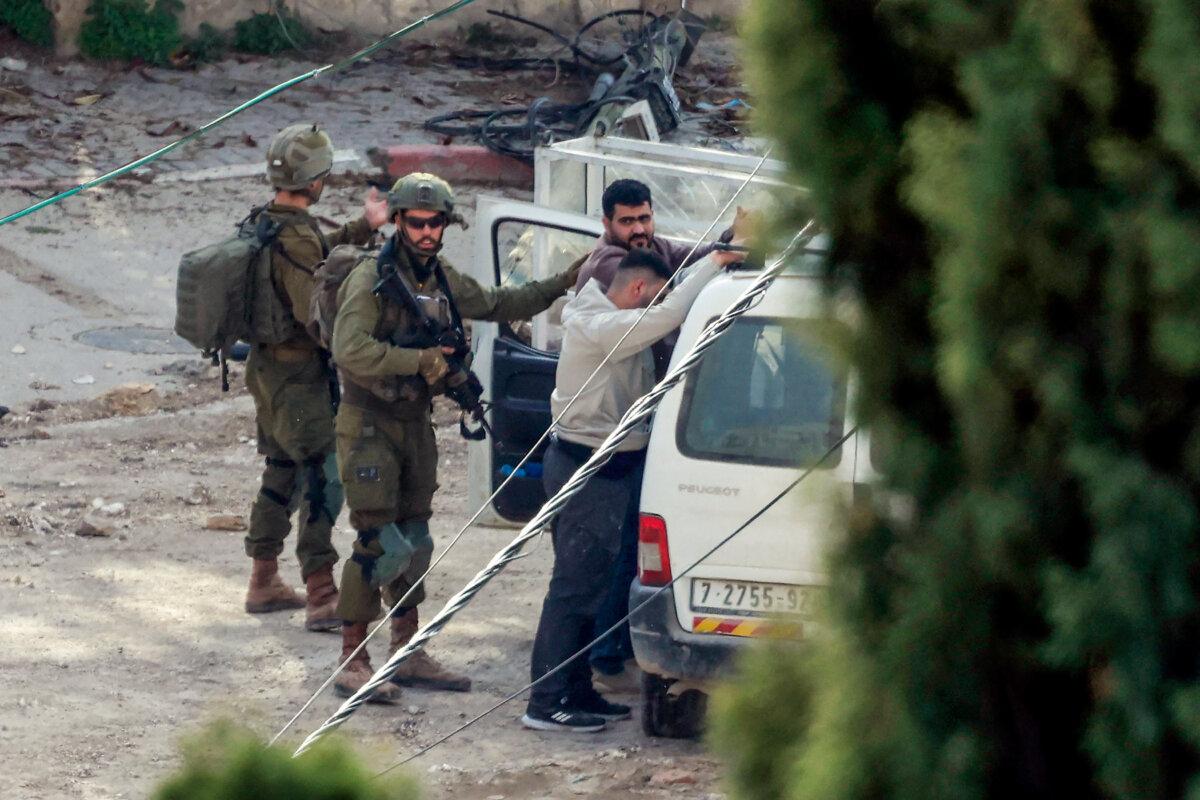 Israeli soldiers detain two men in the Tulkarem camp for Palestinian refugees during an ongoing Israeli military operation in Samaria on Feb. 18, 2025. (Jaafar Ashtiyeh/AFP via Getty Images)