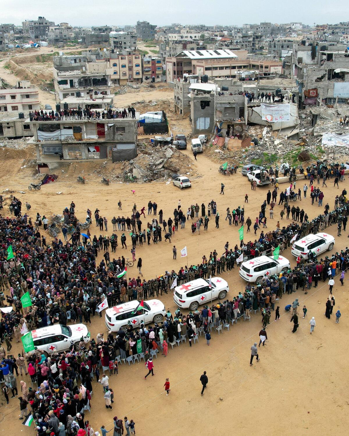 A drone view shows Palestinians and terrorists gathering around Red Cross vehicles in Khan Yunis on Feb. 20, 2025, as the Hamas terrorist group hands over the bodies of deceased hostages Oded Lifschitz, Shiri Bibas, and her two children, Kfir and Ariel Bibas, who were abducted during the Hamas-led deadly Oct. 7, 2023, attack. The body said to be that of Shiri Bibas later turned out to be the remains of an unidentified Gazan woman. (Reuters/Stringer)